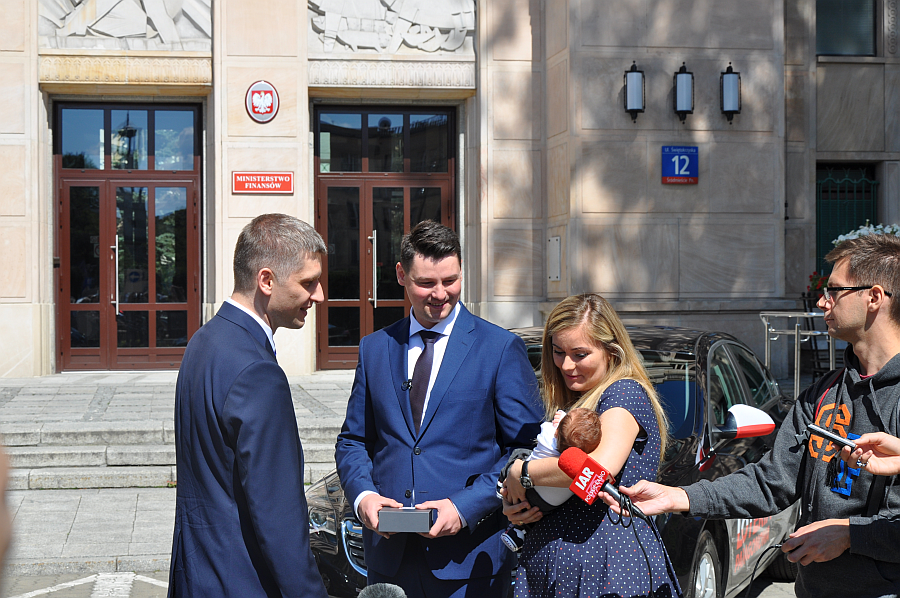 Pan Piotr z rodziną odbiera kluczyki od wiceministra Piotra Nowaka